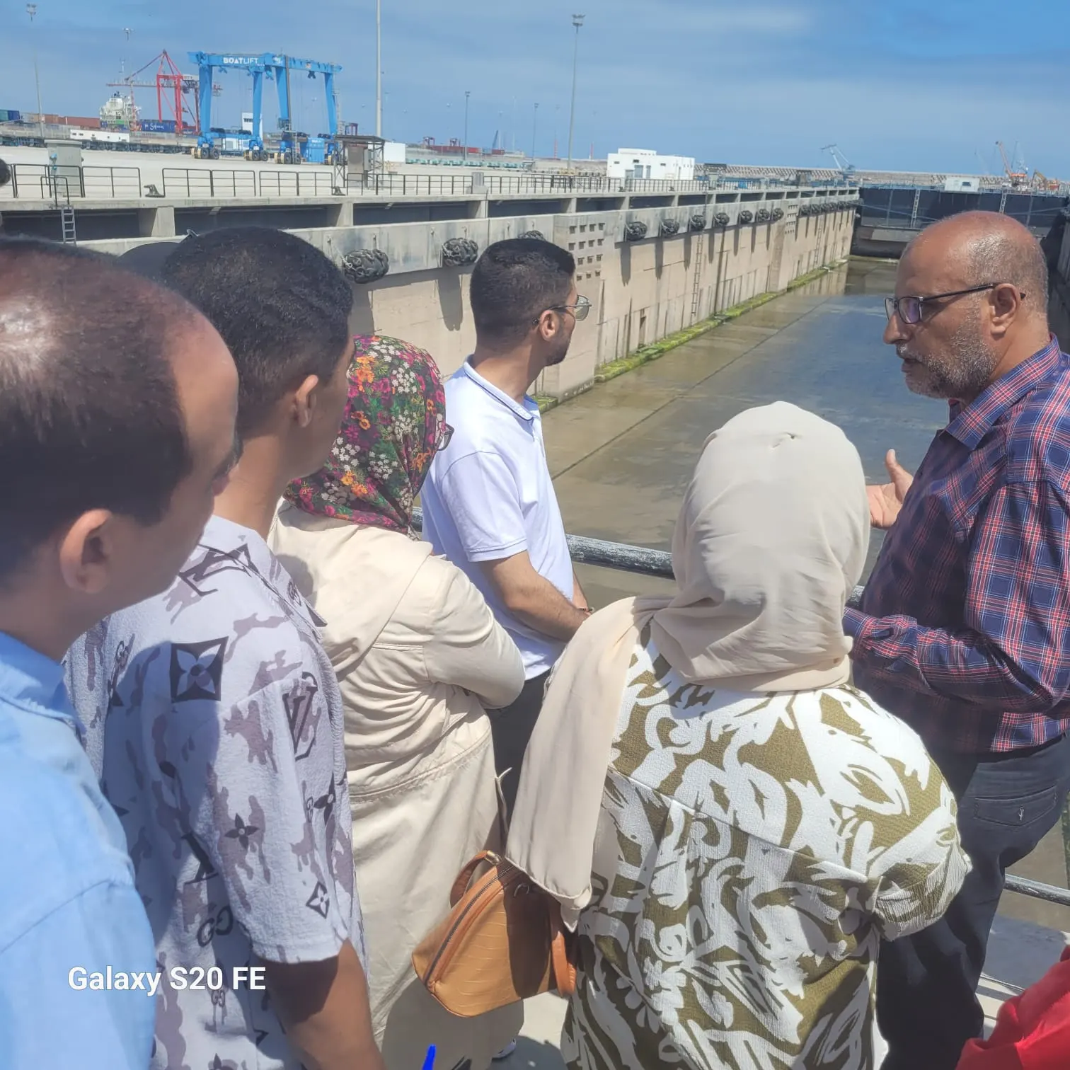 Un professionnel du port explique le fonctionnement d'une forme de radoub à un groupe d'étudiants, port de Casablanca