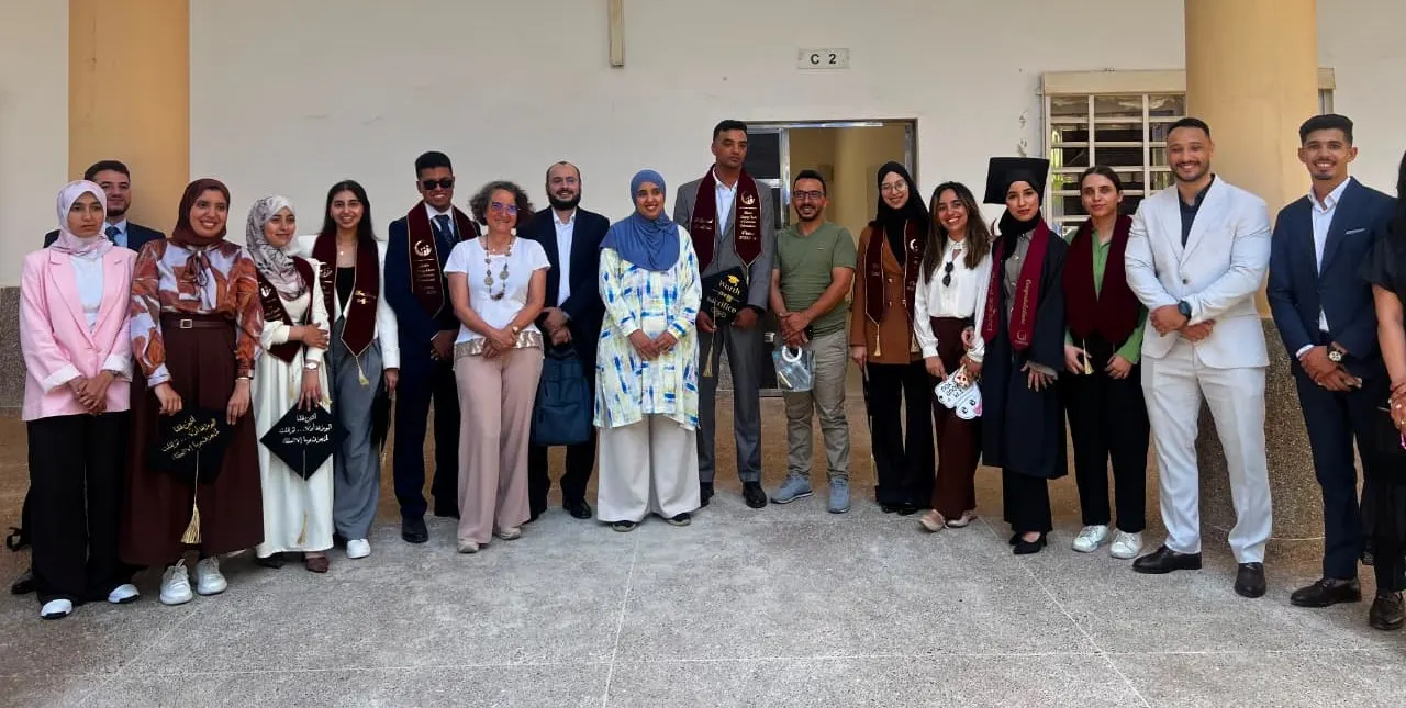 Lauréats du Master en écharpes de diplômés entourant les membres du jury après les soutenances